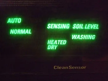 The display on a dishwasher. It has the words “Auto,” “Normal,” “Sensing,” “Heated Dry,” “Soil Level,” and ”Washing” arrayed in no obvious relation to each other.