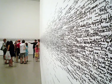 Names and heights written on a wall are dense toward the vertical middle and sparser going up or down